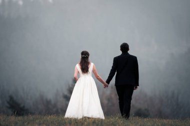 Gelin ve damat el ele tutuşur ve doğanın ortasında geleceğe bakar. Yeni evliler birlikte yürür. Düğün fotoğrafçılığı, ölüm bizi ayırana kadar.