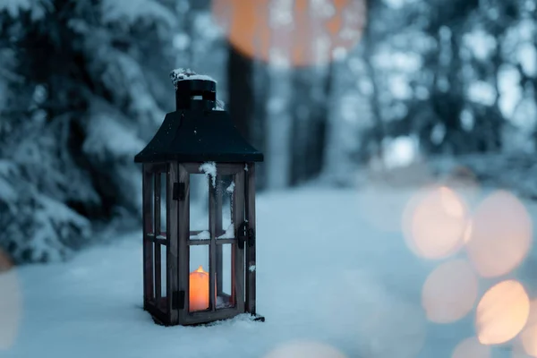 Karlı bir manzaranın ortasında ışıklı bir fener, bir umut lambası, Noel ve soğuk bir atmosfer, karlı bir ormanın ortasında bir sahne, Beytüllahim ışığı, detay, bir fenere yakın çekim