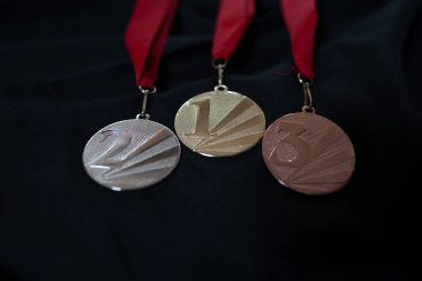 Altın, gümüş ve bronz madalyalar kazananlar için siyah izole edilmiş arka planda numaralar. Üç renkli kurdeleli madalya. 2022 Pekin 'de kış olimpiyatları, afiş ve arka plan için kullanışlı.
