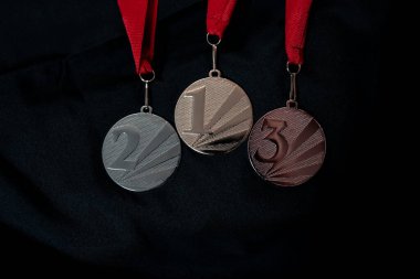 Altın, gümüş ve bronz madalyalar kazananlar için siyah izole edilmiş arka planda numaralar. Üç renkli kurdeleli madalya. 2022 Pekin 'de kış olimpiyatları, afiş ve arka plan için kullanışlı.