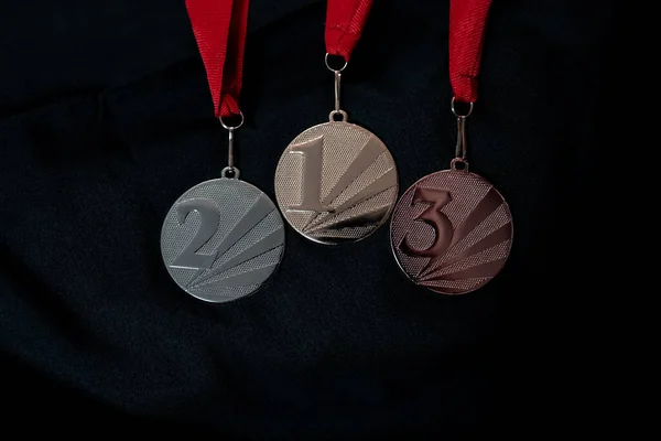 Altın, gümüş ve bronz madalyalar kazananlar için siyah izole edilmiş arka planda numaralar. Üç renkli kurdeleli madalya. 2022 Pekin 'de kış olimpiyatları, afiş ve arka plan için kullanışlı.