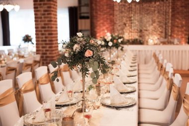 Düğün masası olan güzel bir düğün odası. Yemekler, çiçekler, içecekler, dekorasyonlar, ışıklar her yerde.