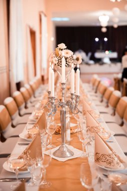 Düğün masası olan güzel bir düğün odası. Yemekler, çiçekler, içecekler, dekorasyonlar, ışıklar her yerde.