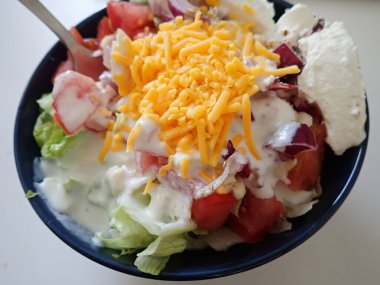 served bowl od a fresh vegetable salad with cheese