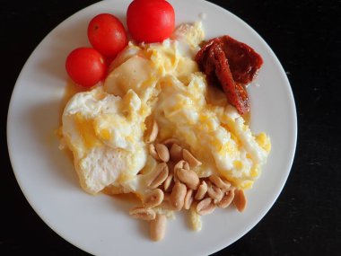 portion of scrambled eggs with vegetables and cheese on a plate