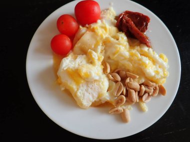 portion of scrambled eggs with vegetables and cheese on a plate