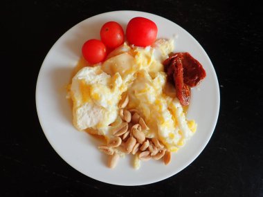 portion of scrambled eggs with vegetables and cheese on a plate