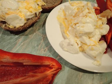 portion of scrambled eggs with vegetables and cheese on a plate