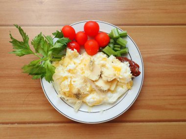 portion of scrambled eggs with vegetables and cheese on a plate