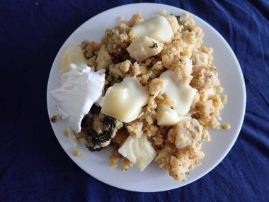 portion of scrambled eggs with vegetables and cheese on a plate