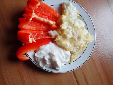 portion of scrambled eggs with vegetables and cheese on a plate
