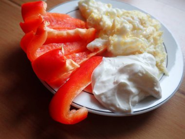 portion of scrambled eggs with vegetables and cheese on a plate