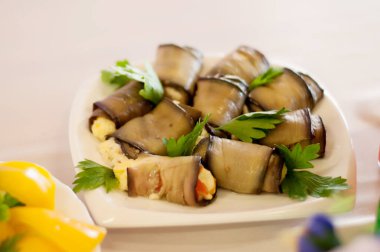 Peynir ve maydanozla doldurulmuş patlıcanlı beyaz tabak.