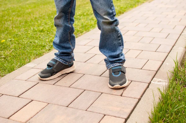 Child Blue Jeans Dirty Knees Dark Sneakers Blue Inserts Stands — Stock Photo, Image