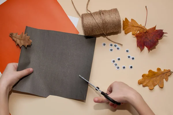 Seorang Anak Memotong Sebuah Kerajinan Halloween Dari Kertas Hitam Dengan — Stok Foto