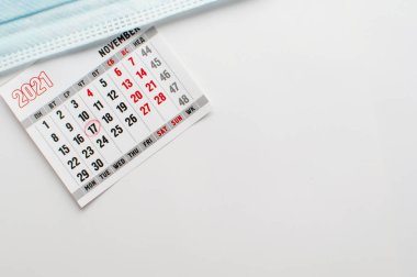 17 Kasım vurgulanmış bir takvim sayfası ve yazı için yeri olan beyaz bir arka plan üzerinde tıbbi maske
