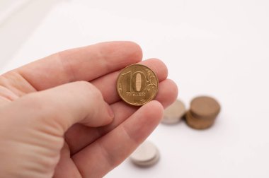 Beyaz arka planda elinde 10 Rus rublesi var.