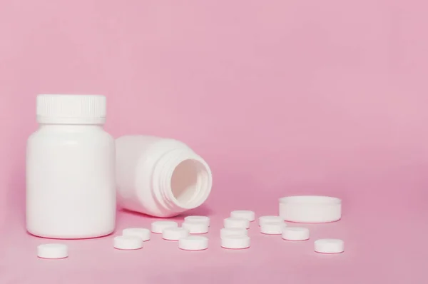 Две Немеченые Бутылки Белого Лекарства Разбросанные Таблетки Розовом Фоне — стоковое фото