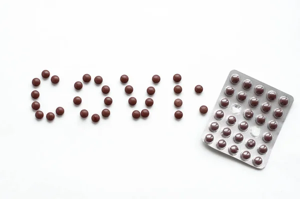 Napis Covid Tabletek Kolorze Brązowym Białym Tle — Zdjęcie stockowe