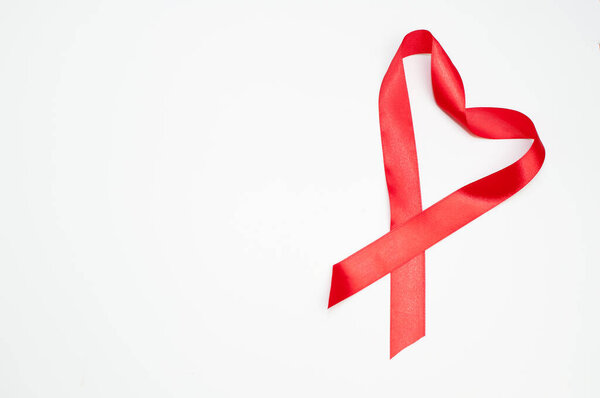 red satin ribbon in the form of a heart on a white background