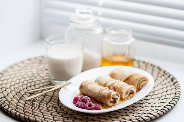 Pancakes Rolled White Plate Frozen Raspberries Honey Background Glass Milk — Stock Photo, Image