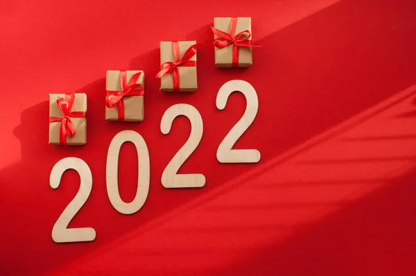 红色缎带工艺包装中的礼品和红色背景中带有文本位置的编号2022的礼品 — 图库照片