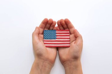 Amerika Birleşik Devletleri bayrağı, beyaz arka planda, çocukların avuçlarında plastikten yapılmıştır.
