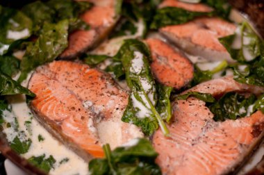 Dilimlenmiş kırmızı balık bifteği, krema ve otlarla pişirilmiş.