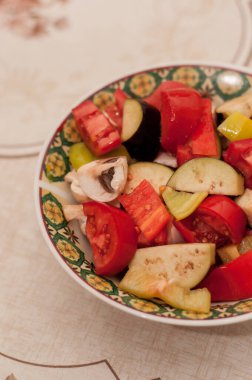 Dilimlenmiş sebzeler - mantarlar, domatesler, tatlı biberler - salata, güveç veya ızgara sebze yapmak için malzemeler bir tabakta; dikey formatta;