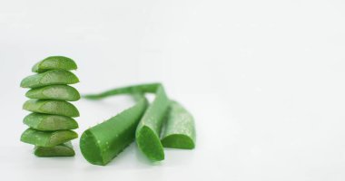 Dilimlenmiş aloe yaprakları ve aloe yaprakları hafif bir arka planda, pankartlar için