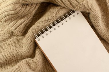 Yün örülmüş bir battaniyeye yazılacak temiz bir kağıt defter.