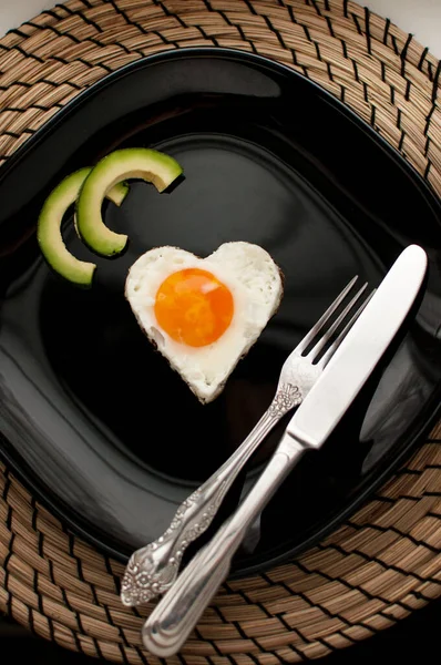 Ovos Mexidos Forma Coração Com Abacate Uma Placa Preta Guardanapo — Fotografia de Stock