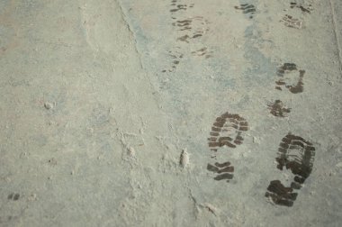 wet bootprints on dirty concrete floor