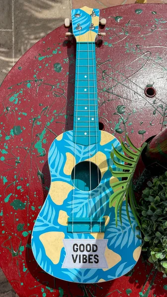 Üzerinde yazı olan renkli küçük bir gitar. Güzel titreşimler.