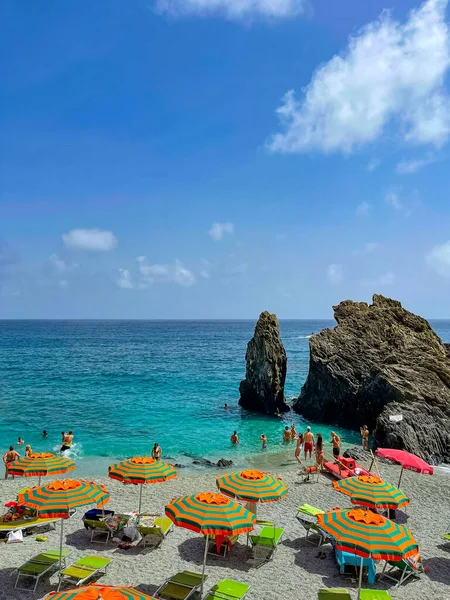 Çizgili turuncu plaj şemsiyeli Cinque Terre plajı.