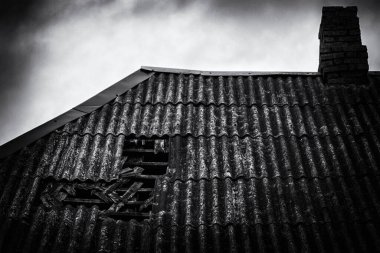 Bacalı eski kiremitli çatı. Kırsal bir ev, çatısı kırık.