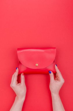 Parlak yaz moda aksesuarları. Kırmızı arka planda kırmızı deri çanta ya da el çantası. Parlak manikür torbalı kadın elleri. Üst Manzara. Düz Yat.