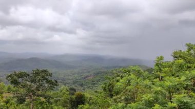 Kerala 'da turistik bir bölgede, bulutlu gökyüzünün altındaki tepelerin ve vadilerin uzak manzarası.