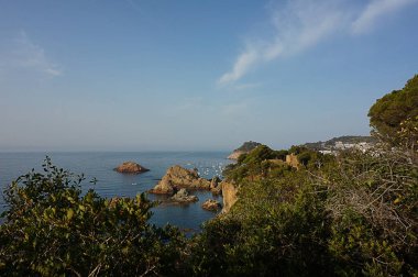 Deniz manzarası, dağlar, ağaçlar, yazları gökyüzü Tossa de mar 'da
