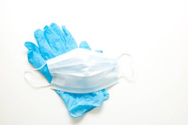 Beyaz arka planda tıbbi eldiven ve maske