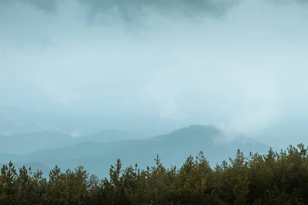 Arkasında bulutlar ve dağlar olan güzel bir manzara.