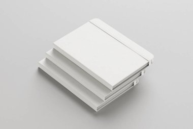Boş beyaz kitap yığını ya da Gri arkaplandaki desenli kapağı olan defterler. 3d oluşturma.