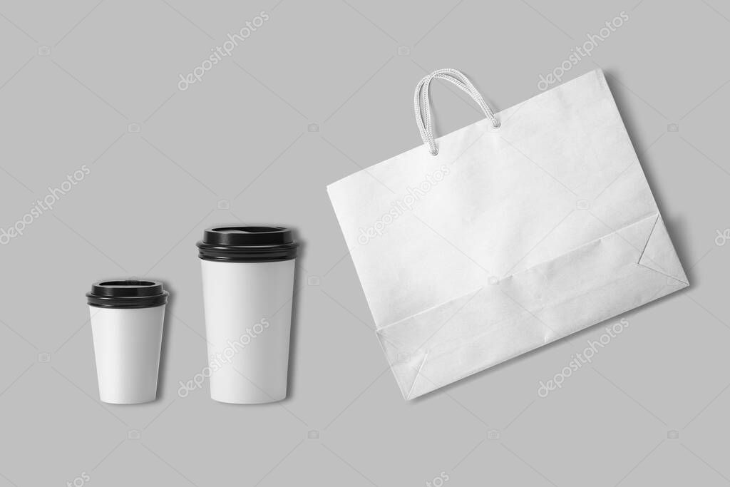 Coffeeshop branding mockup isolated on a grey background. Two cardboard coffee cups and kraft paper shopping bag ready for coffeeshop or coffeehouse design. 3d rendering. eco friendly and zero waste.