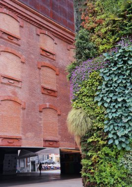 Madrid, İspanya - Mayıs 2018: Dikey bahçe duvarı ve Herzog ve de Meuron tarafından tasarlanan CaixaForum Müzesi 'nin tuğla cephesi