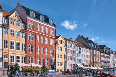 Kopenhag, Danimarka - Eylül 2022: Renkli Geleneksel ev mimarisi ve Nyhavn Limanı 'ndaki kanal dolgusu üzerindeki tekneler