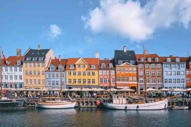 Kopenhag, Danimarka - Eylül 2022: Renkli Geleneksel ev mimarisi ve Nyhavn Limanı 'ndaki kanal dolgusu üzerindeki tekneler