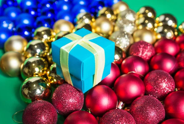Renkli Noel Süslemeleri Üzerinde Fiyonk Olan Bir Hediye Kutusu Masaya — Stok fotoğraf
