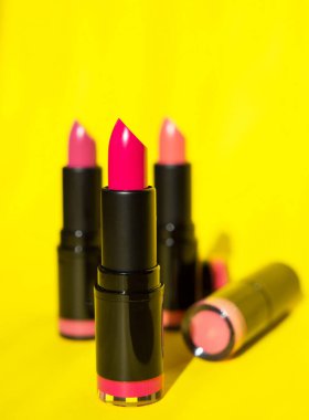 Pembe gözlüklü, sulu bir ruj. Kızlar için makyaj. Sarı arka planda parlak ruj izi var. Bir makyözün arka planı olarak fotoğrafçılık. Bir blog yazarı için makale, modaya uygun kozmetik ürünler. metin için temsto.