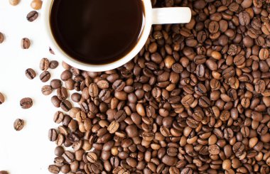 Beyaz arka planda bir fincan aromatik kahve ve dağınık kahve taneleri. Günaydın. Bir çeşit sveru. Düz yat. mesaj için yer. Kahve zamanı..