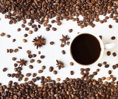 Beyaz arka planda bir fincan aromatik kahve ve dağınık kahve taneleri ve yıldız anason. Günaydın. Bir çeşit sveru. Düz yat. mesaj için yer. Kahve zamanı..